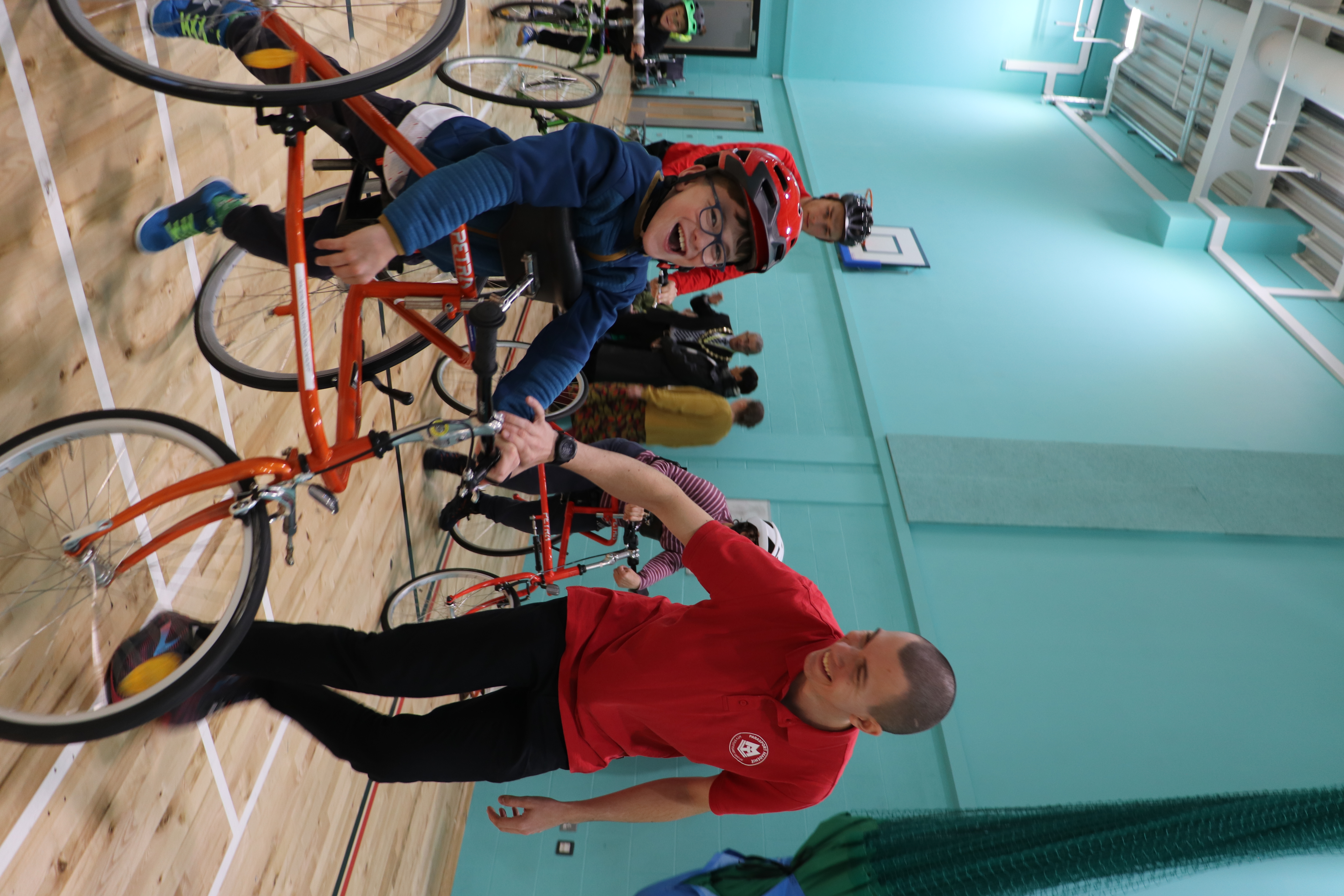 Samuel im Running Frame läuft lachend zusammen mit Trainer Hannes der ebenfalls lacht.