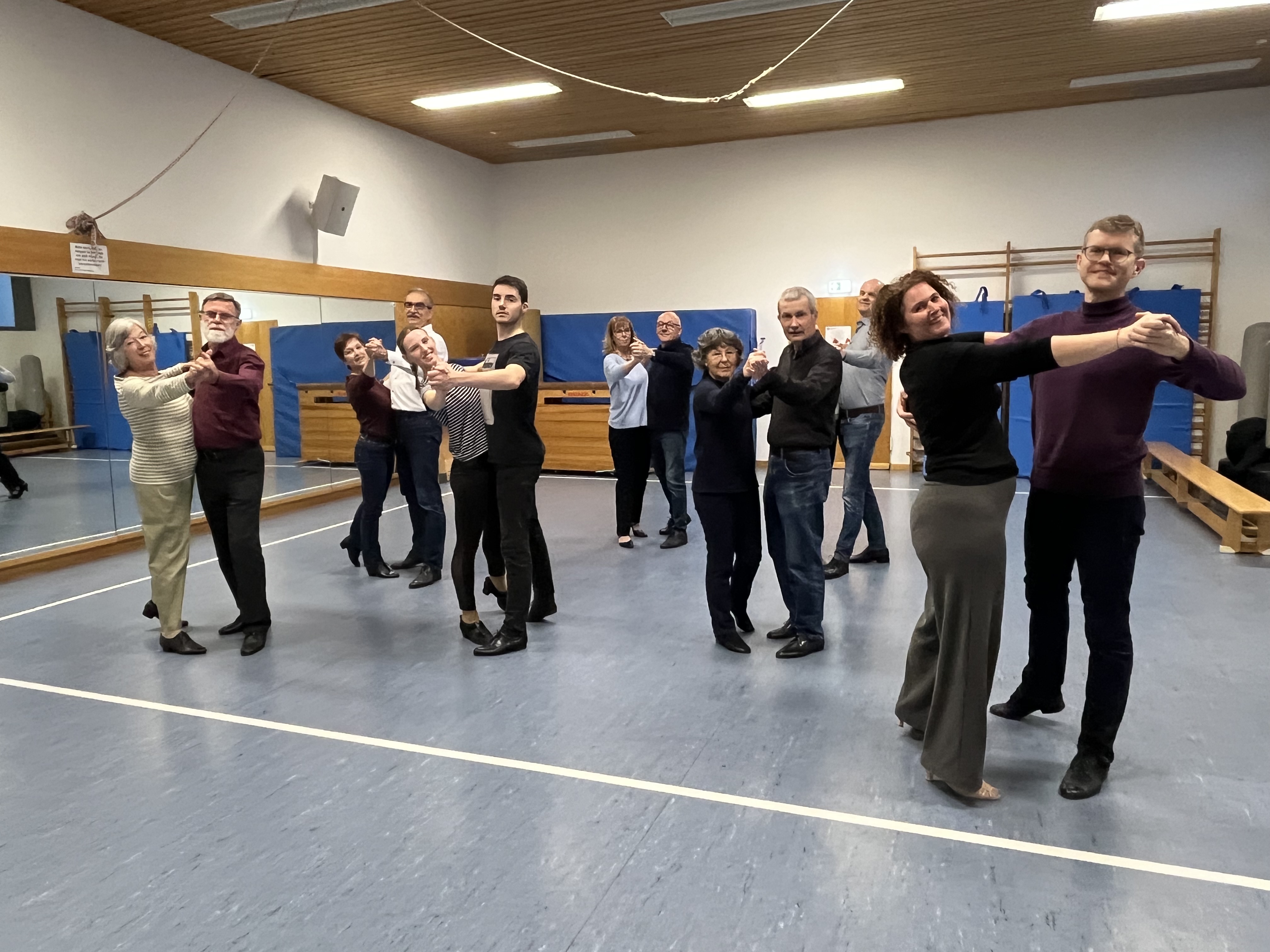 Bild zeigt 7 freundlich lächelnde Tanzpaare beim Tanz in der Großen Gymnastikhalle des MTV. Die Blicke dem Betrachter zugewandt