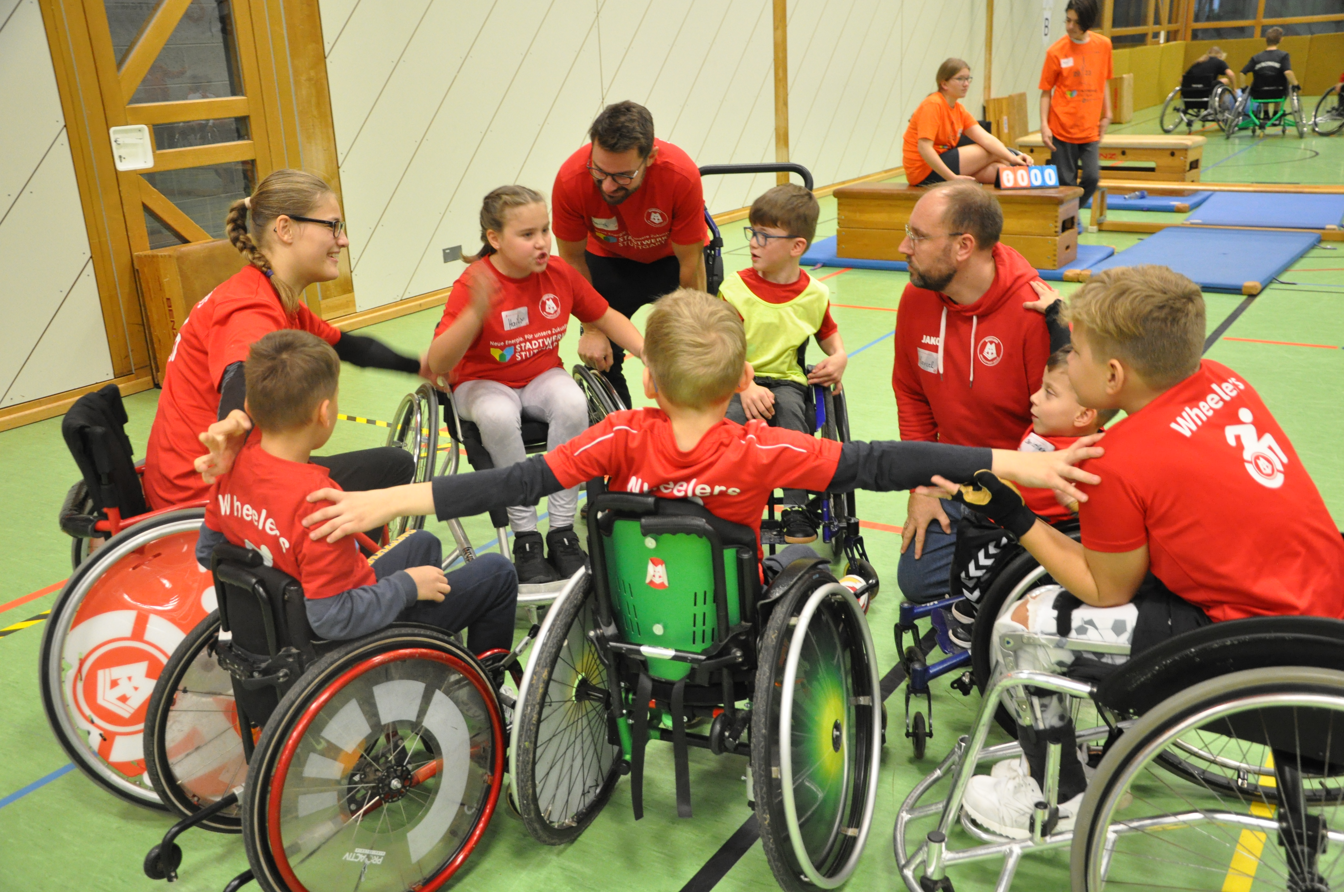 Bild zeigt die Rollikids als Mannschaft beim Wheelsoccer Cup, wie sie sich gerade als Team auf das nächste Spiel einstimmen.